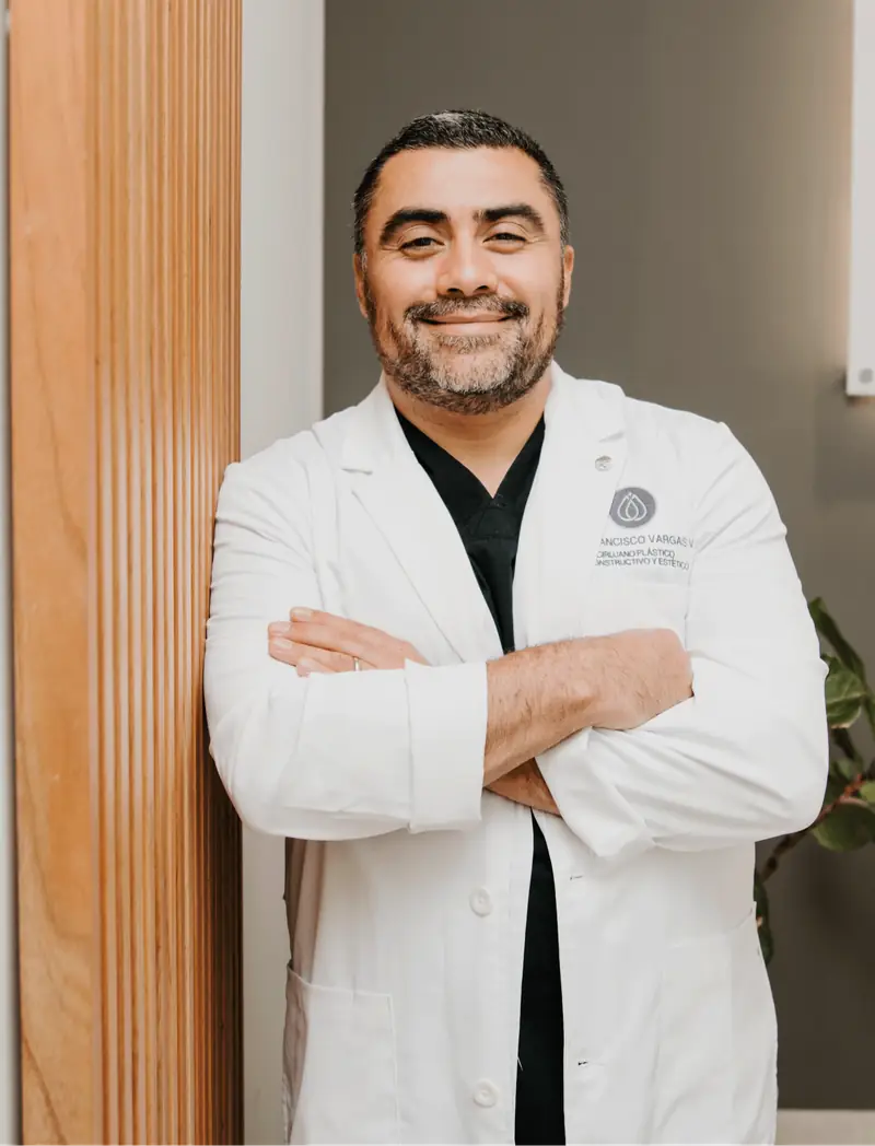 Dr. Francisco Vargas Villalobos, cirujano plástico en bata blanca, retrato con luz cálida natural